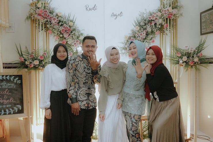 1 Group of people posing at a wedding event with floral decorations.jpg