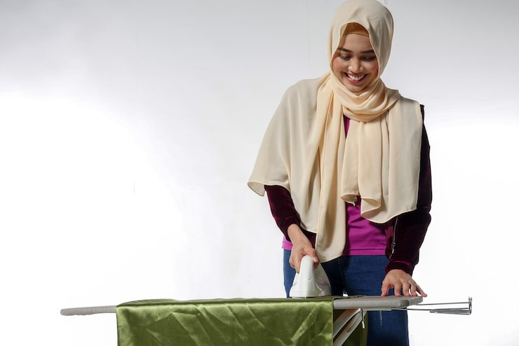 1 Woman in hijab ironing clothes.png